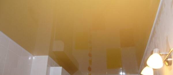 Глянцевый натяжной потолок желтого цвета в ванную
